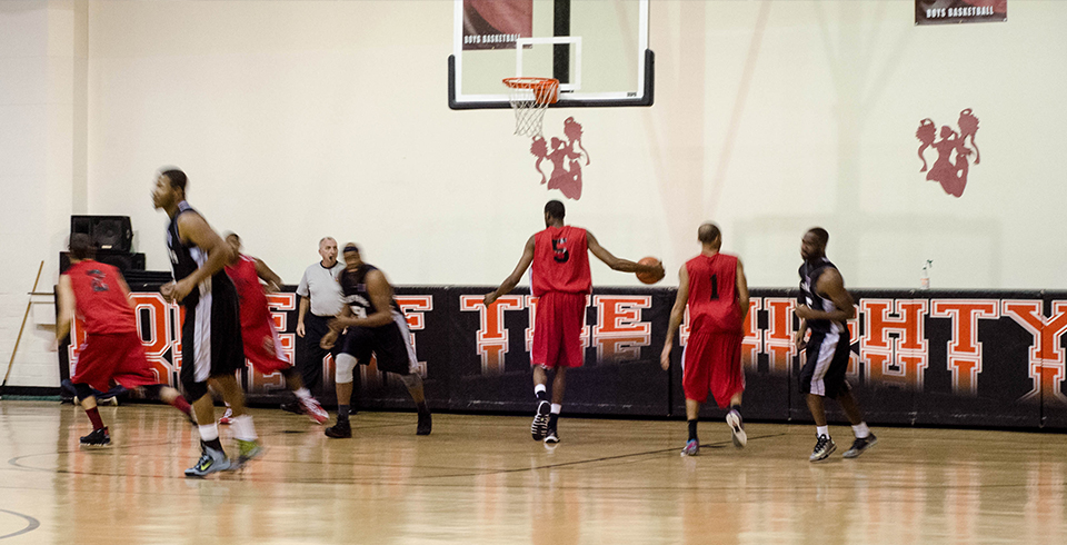 Basketball player rising to the rim under arena lights